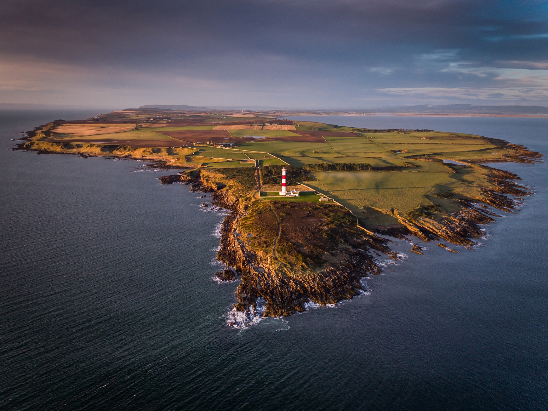 Coastal peninsula lighthouse aerial shot