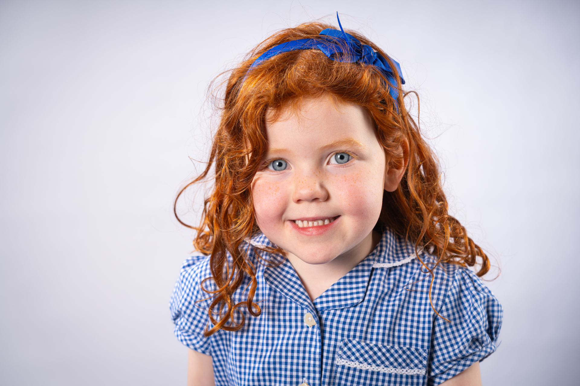 Individual school portrait - girl with red hair and blue headband