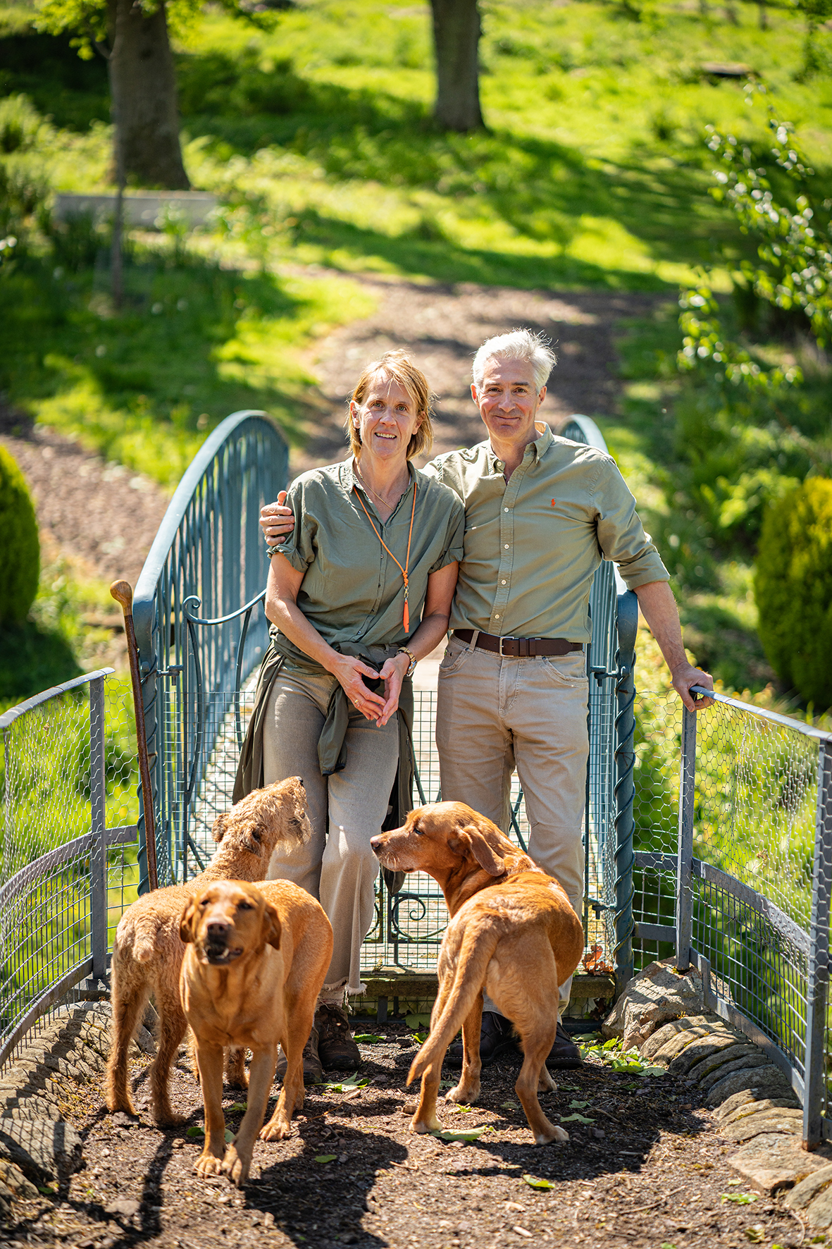 Robbie Douglas-Miller with partner and gundogs on garden bridge